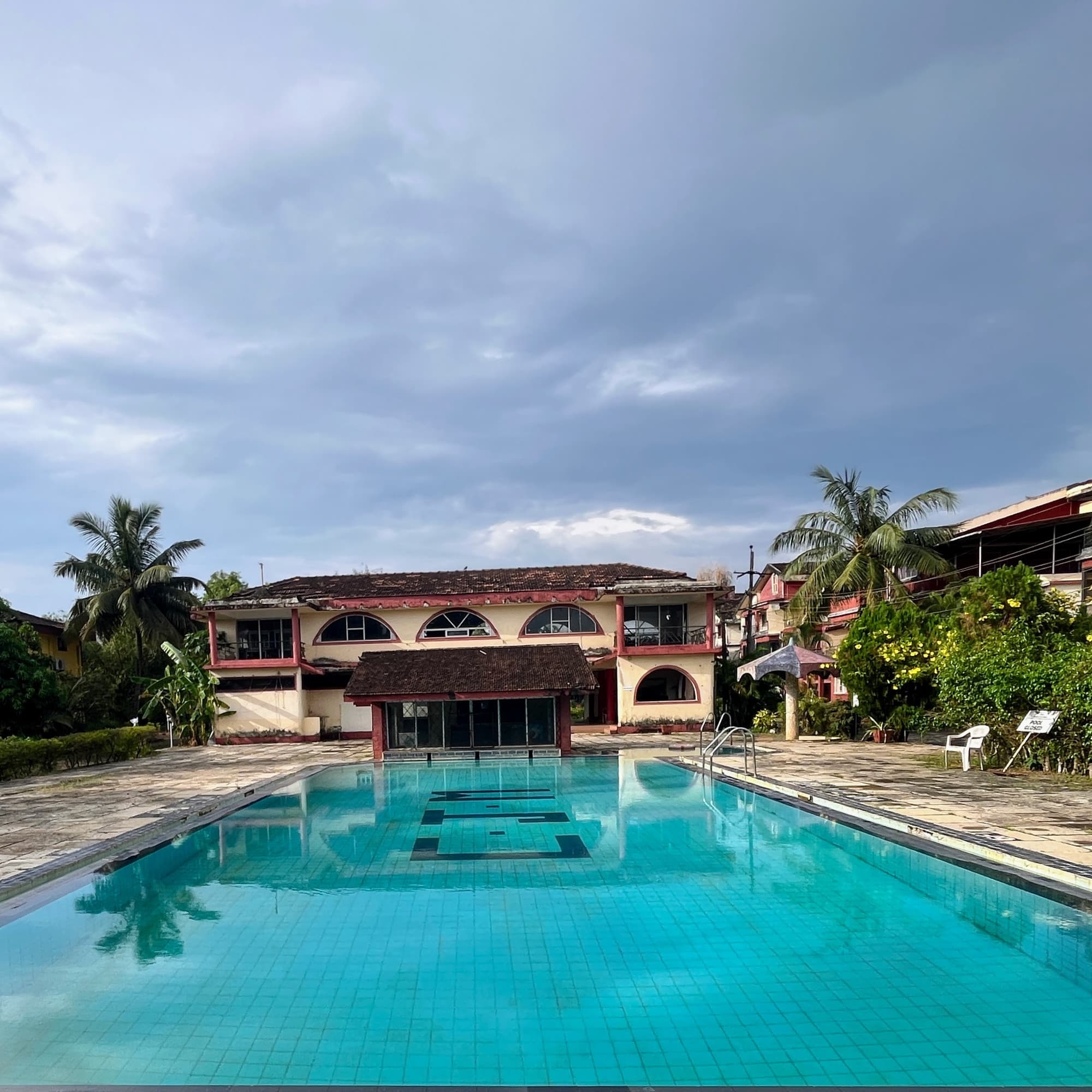 The complex’s shared swimming pool, palm trees behind it