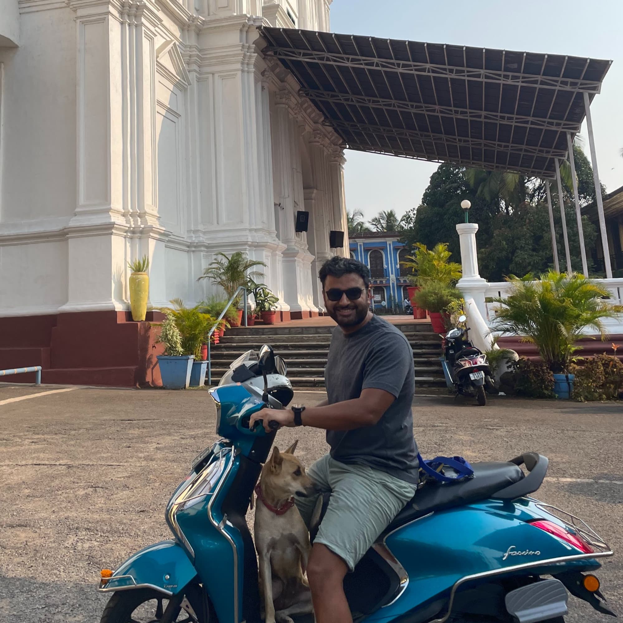 Garvit and one of the dogs on a scooter outside a Goan church