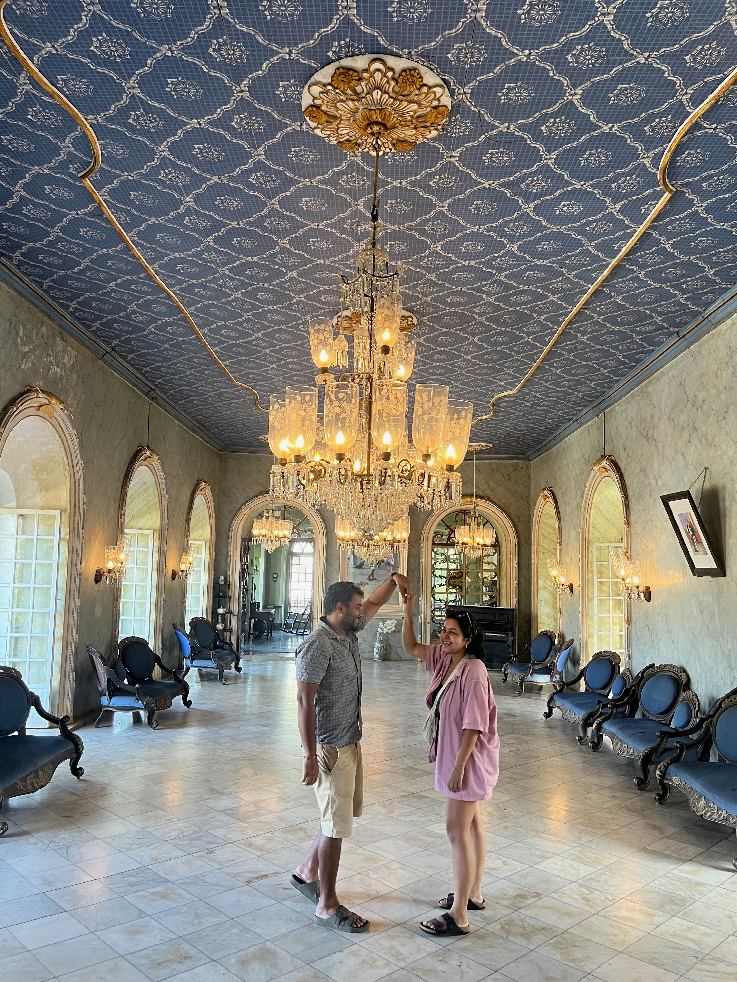 Sanchita and Garvit dancing in a grand chandeliered hall