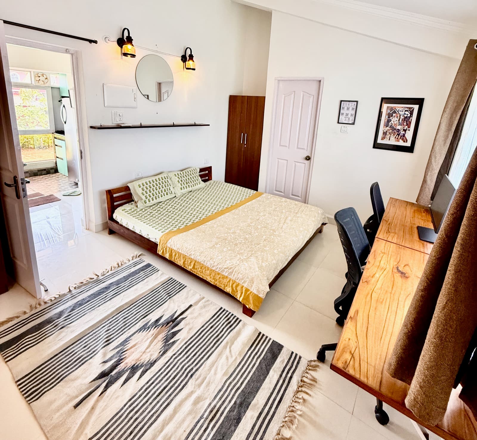 The Sunset Room's bedroom, round mirror and warm wall lights